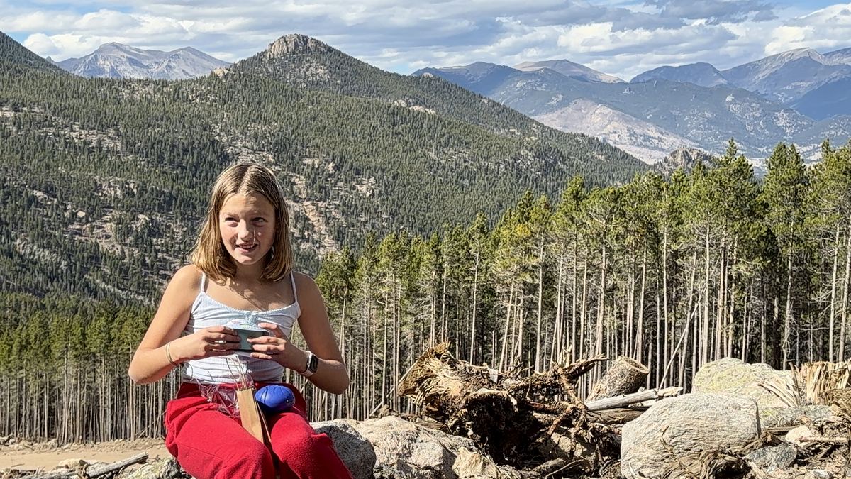 Rebekah sitting on the rocks taking in the mountain view