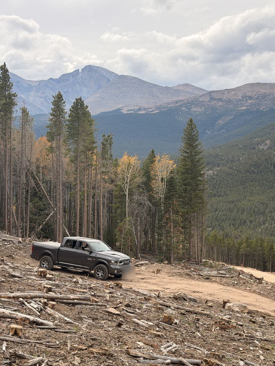 The truck parked in the fire mitigation clearing with Longs Peak behind