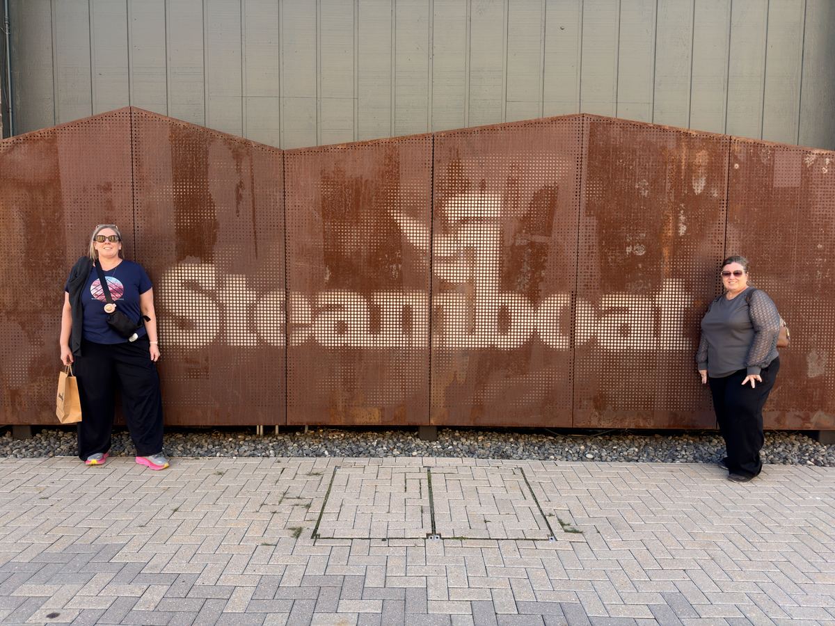 Kim and Karol flanking the Steamboat sign, photographed from above